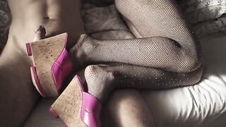 The sexy girl shows off her feet in high heels and pantyhose