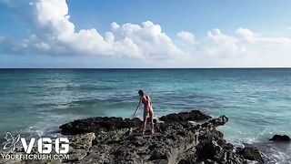A sexy girl is naked on the beach and caresses her body