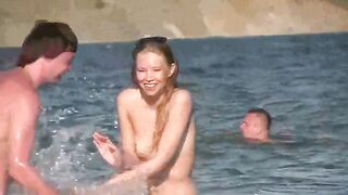 A mature woman is completely naked on the sandy beach