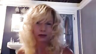 A golden-haired mature woman plays with herself in the bathroom with a vibrator