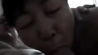 An Asian woman practices blowjob with her lover