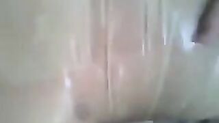 A guy masturbates his dick with a condom on it