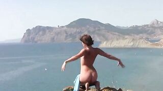 A naked girl is sunbathing on the sandy coast of the sea