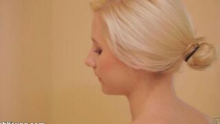 A cute girl caresses herself with a brush in the bathroom