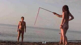 A naked girl is having fun on the beach with her companion