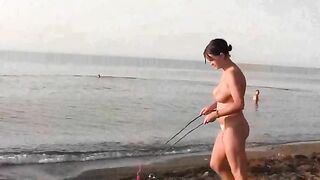 A naked girl is having fun on the beach with her companion
