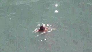 A pair of naked people enjoy each other at sea