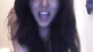 An Asian girl caresses herself on the bed and moans