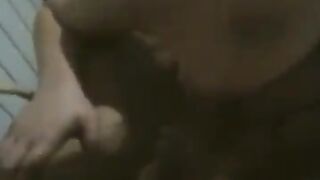A fat woman is dancing on the bed in front of her husband