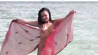 A girl is bathing in the nude in the sea, capturing a risky moment