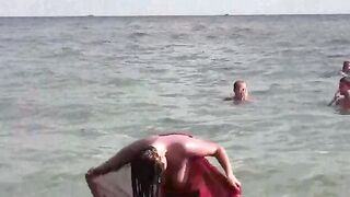 A girl is bathing in the nude in the sea, capturing a risky moment