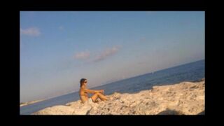 A young girl sunbathes naked on the beach. It's not every day to see that