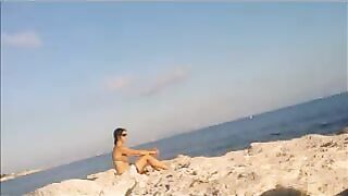 A young girl sunbathes naked on the beach. It's not every day to see that