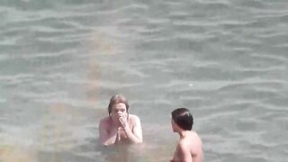 A group of naked girls are having fun in the sea