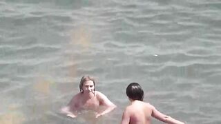 A group of naked girls are having fun in the sea